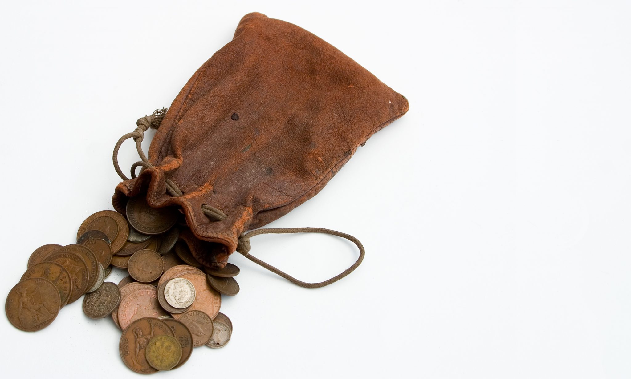 Worn leather purse spilling coins out onto white countertop Jüdische